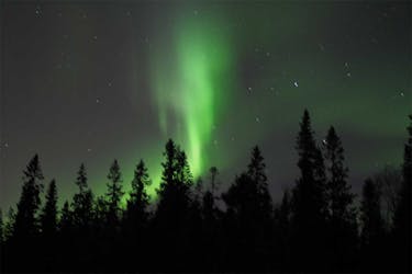 Caminhada pela natureza com raquetes de neve na aurora boreal